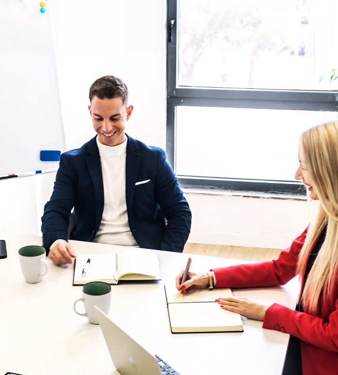 Anna coaching a client one-on-one, both engaged and smiling during a strategy session.