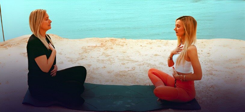 Anna with a client practicing meditation and breathwork on a mat for mindfulness coaching.