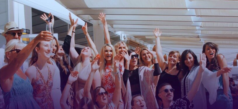 Anna and a group of professionals celebrating success with hands raised and big smiles, symbolizing growth, business wins, and community support