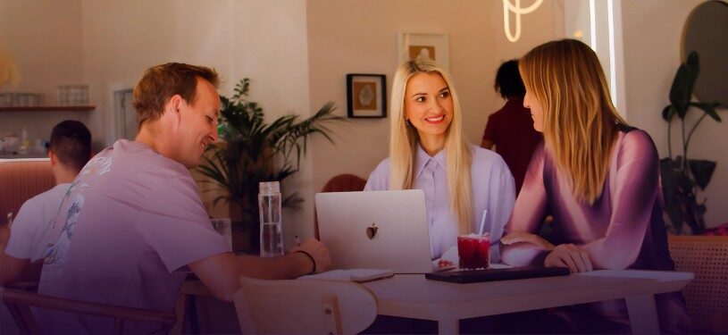Anna coaching two business leaders in a strategy session, all smiling and engaged.